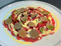 Objednať Carpaccio di manzo Fassona con fonduta di Parmigiano Reggiano e tartufo nero