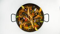 Objednať Paella el Cid připravená z rýže, kalamárů, mušlí, krevet, zeleniny a šafránu